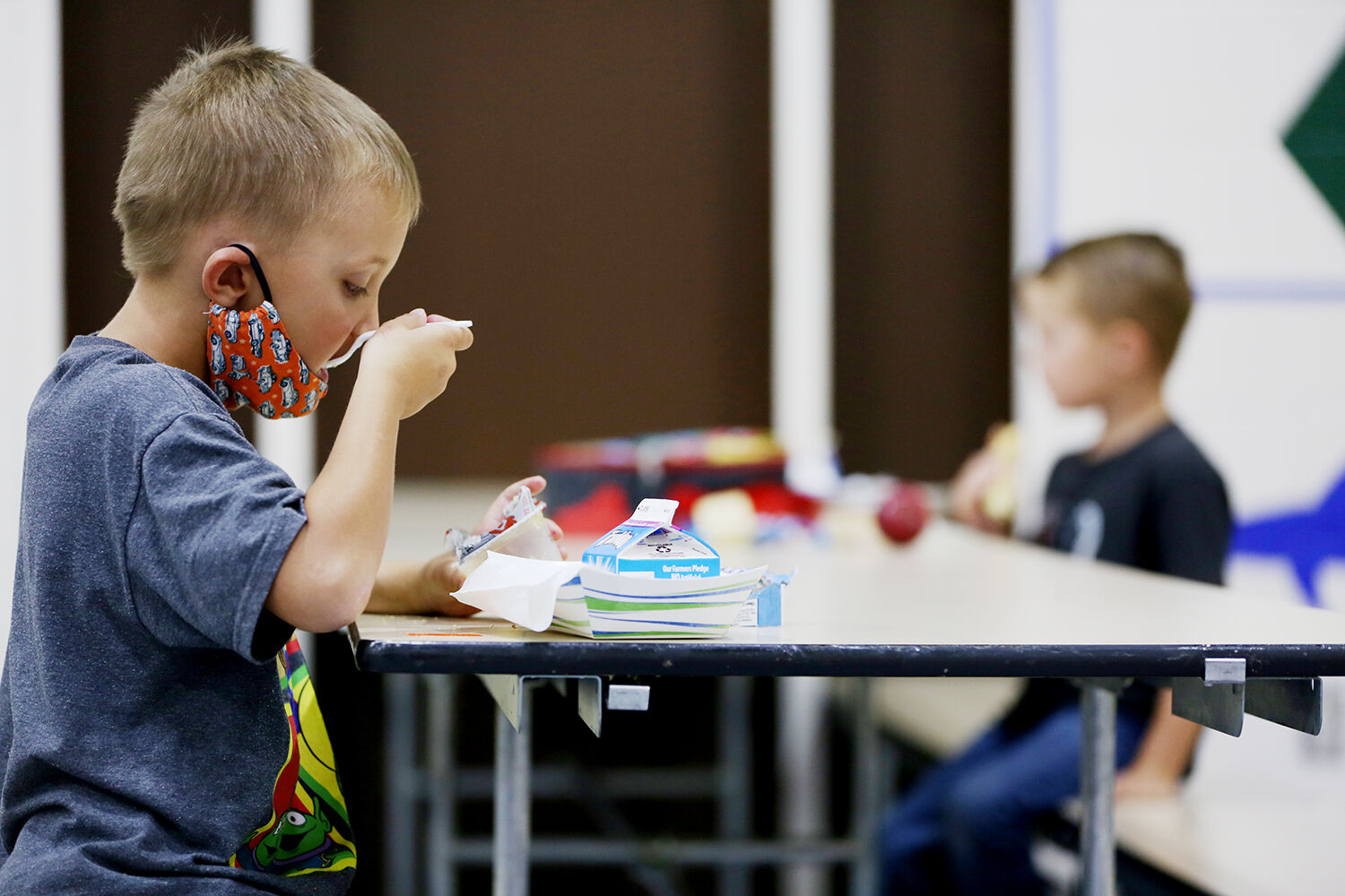 Billy Berus, 5, finishes the final bites of his applesauce with his cars mask